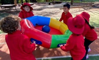 A group of children playing with a ball Description automatically generated