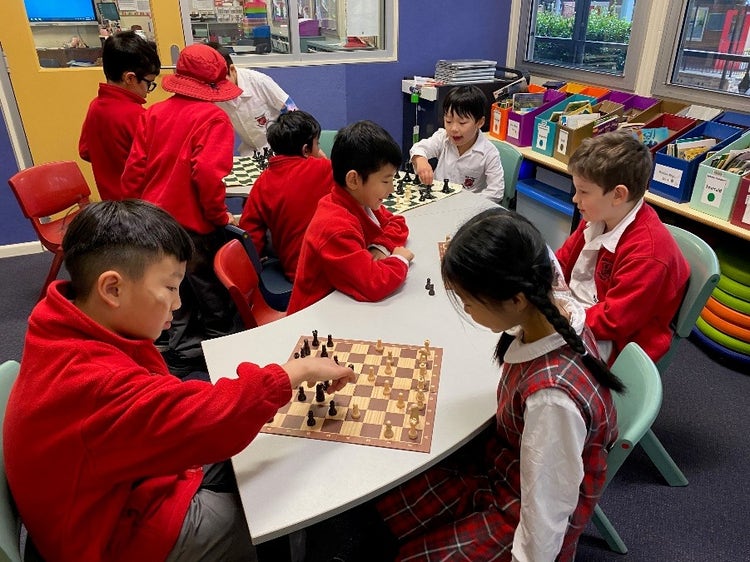 A group of children playing chess Description automatically generated